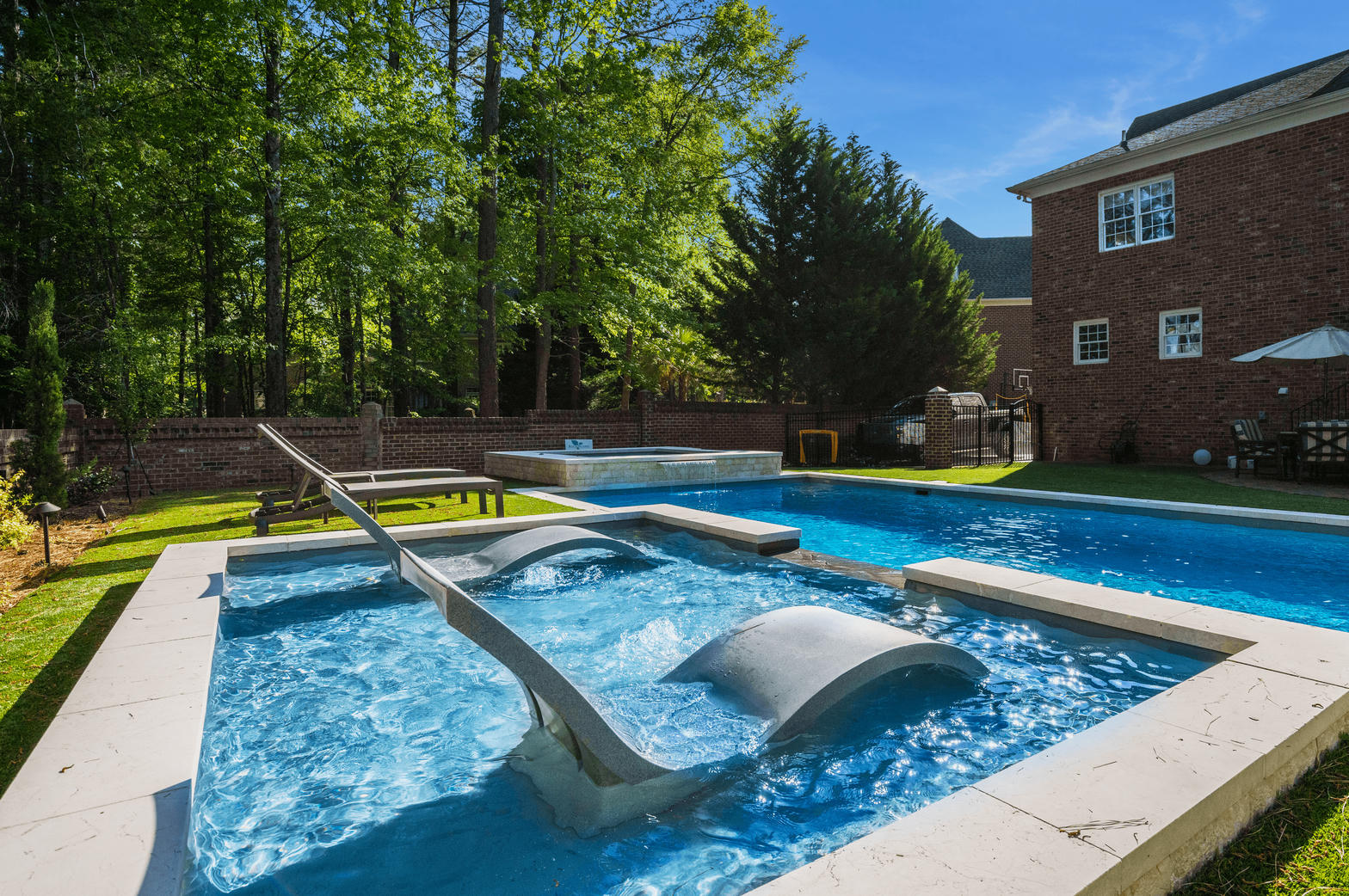 In-ground swimming pool with a raised spa