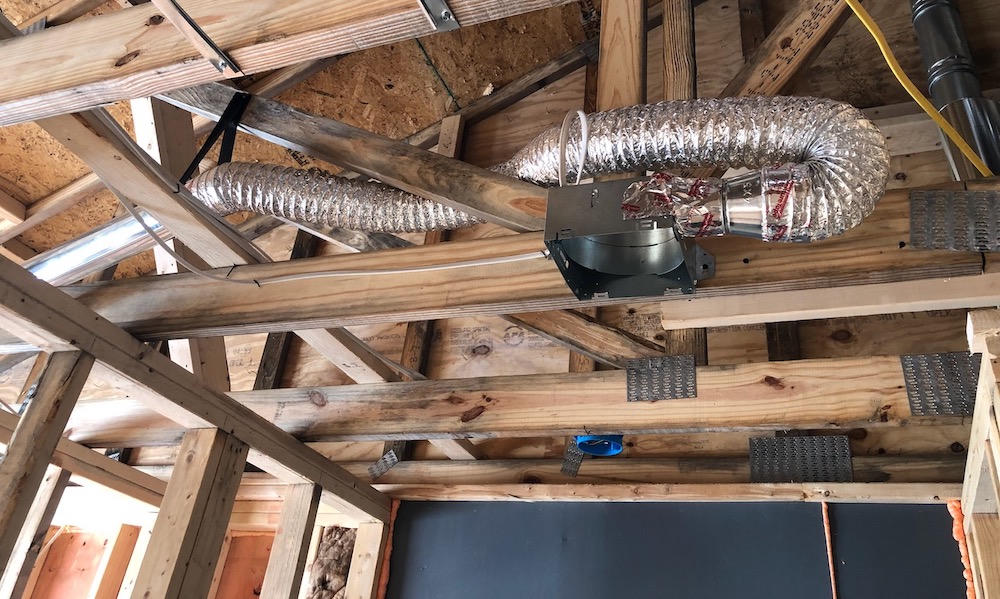Ductwork running through open ceiling joists before drywall