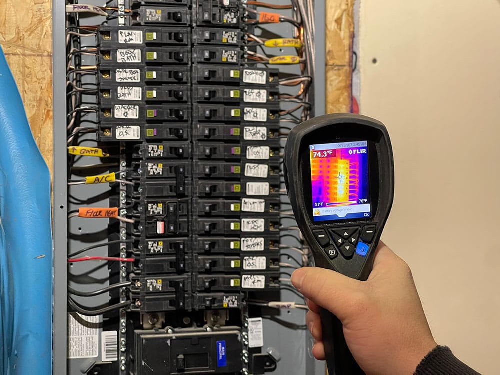 Thermal camera scanning an electrical panel during a home inspection